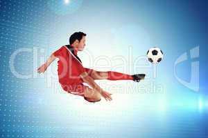 Composite image of football player in red kicking