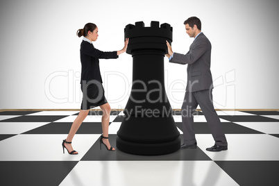 Composite image of business people pushing chess piece