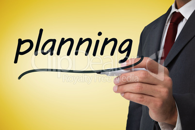 Businessman writing the word planning