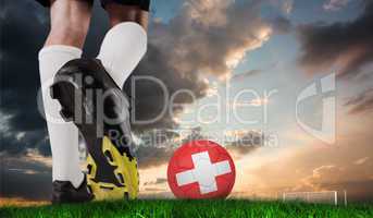 Composite image of football boot kicking swiss ball