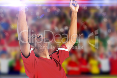 Composite image of excited handsome football fan cheering