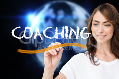 Businesswoman writing the word coaching