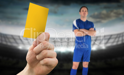 Composite image of hand holding up yellow card