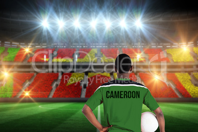 Composite image of cameroon football player holding ball