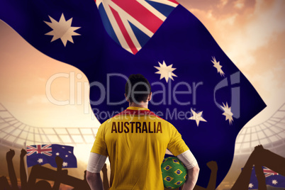 Composite image of australia football player holding ball