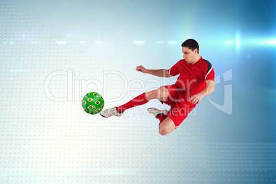 Composite image of fit football player jumping and kicking