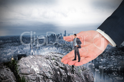 Composite image of serious businessman with hands on hips in lar