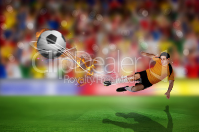 Composite image of football player in orange kicking
