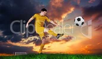 Composite image of football player in yellow kicking