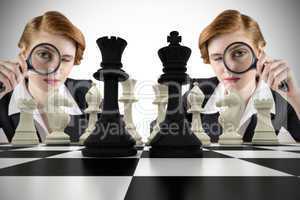 Composite image of focused businesswoman with magnifying glass