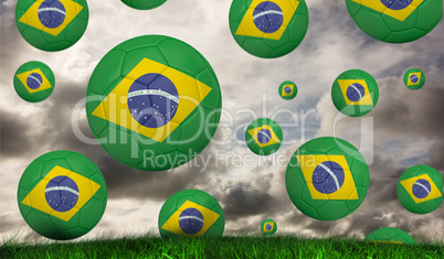 Composite image of footballs in brasil flag colours
