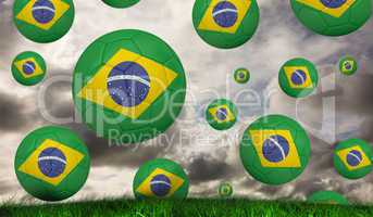 Composite image of footballs in brasil flag colours