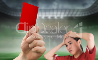 Composite image of hand holding up red card