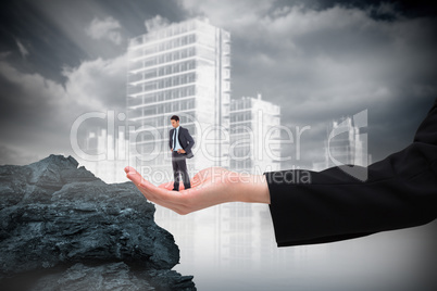 Composite image of serious businessman with hands on hips in lar