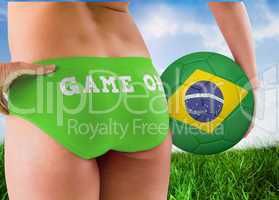 Composite image of fit girl holding brasil ball