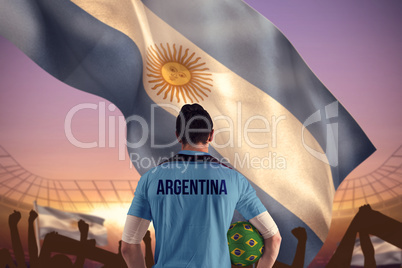 Composite image of argentina football player holding ball