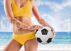 Composite image of fit girl in yellow bikini holding football