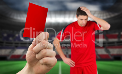 Composite image of hand holding up red card