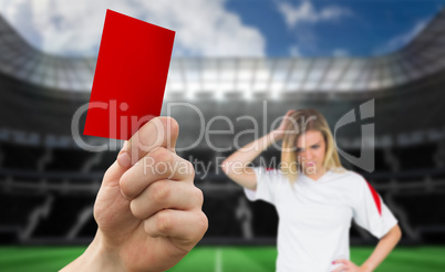 Composite image of hand holding up red card