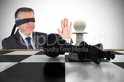 Composite image of mature businessman in a blindfold