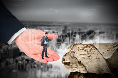 Composite image of serious businessman with hands on hips in lar