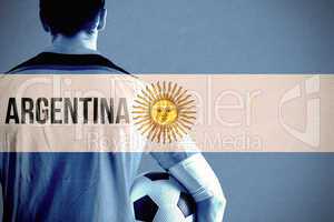 Composite image of argentina football player holding ball