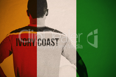 Composite image of ivory coast football player holding ball