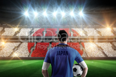 Composite image of japan football player holding ball