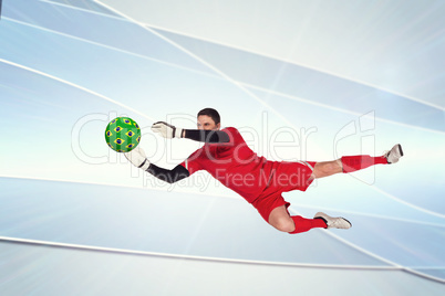 Composite image of fit goal keeper jumping up