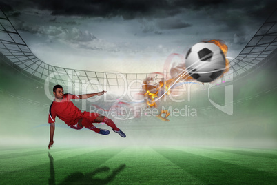 Composite image of football player in red kicking