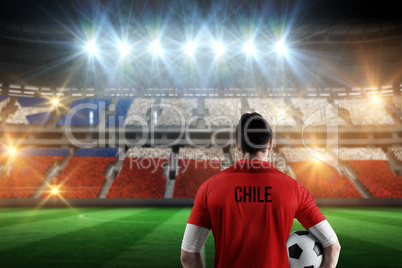 Composite image of chile football player holding ball