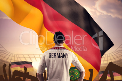 Composite image of germany football player holding ball