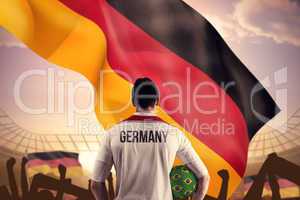 Composite image of germany football player holding ball