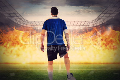 Composite image of handsome football player in blue jersey