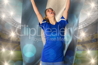 Composite image of cheering football fan in blue jersey holding
