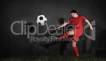 Composite image of football player in red kicking