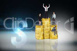 Composite image of business people on pile of coins