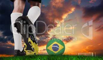 Composite image of football boot kicking brazil ball
