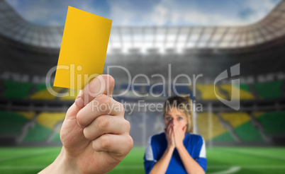 Composite image of hand holding up yellow card