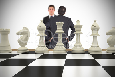 Composite image of businessmen and chess pieces