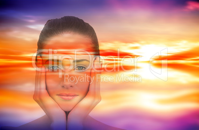 Composite image of beautiful brunette with hands on face