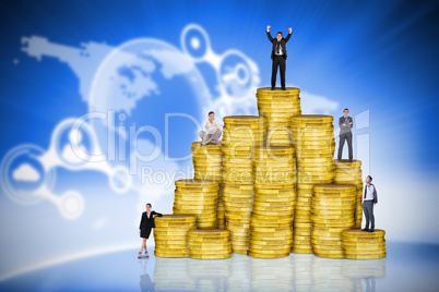 Composite image of business people on pile of coins