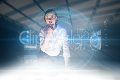 Composite image of redhead businesswoman using interactive desk