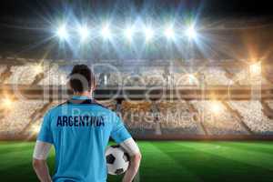 Composite image of argentina football player holding ball