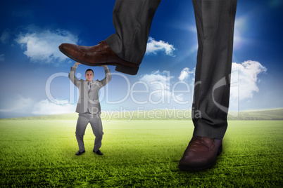 Composite image of businessman stepping on tiny businessman