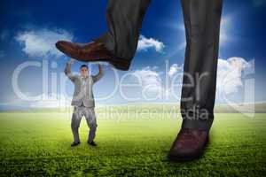 Composite image of businessman stepping on tiny businessman