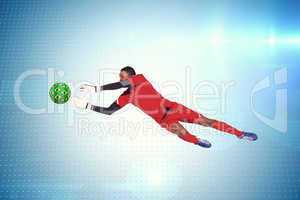 Composite image of goalkeeper in red making a save