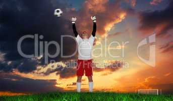 Composite image of goalkeeper in white cheering