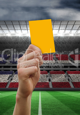 Composite image of hand holding up yellow card