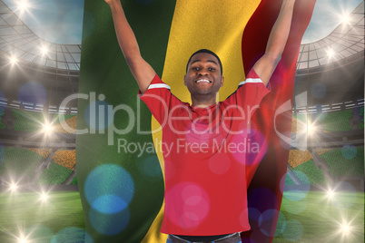 Composite image of excited handsome football fan cheering holdin